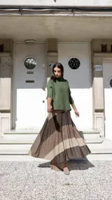 Conjunto de sweater y pollera plisada con diseño de líneas horizontales con lurex. El sweater es de corte holgado y la pollera tiene elástico en la cintura.