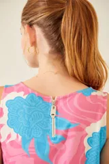 Vestido corto sin mangas con estampado floral en tonos rosa, celeste y blanco.