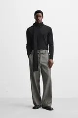Pantalón gris de corte recto con cinturón de la misma tela, bolsillos laterales y traseros de vivo.