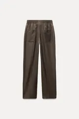 Pantalón de tiro medio color marrón, con cintura elástica ajustable con cordones, bolsillos delanteros y traseros, raya planchada y pierna recta.