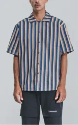 Camisa de manga corta con cuello cubano y estampado a rayas verticales en tonos azul, amarillo y rojo.