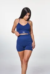 Conjunto deportivo azul marino compuesto por un top con breteles finos y logo blanco, y un short de cintura alta.
