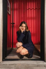 Vestido corto de tejido calado a rayas verticales en tonos blanco, lila, amarillo y borgoña, con mangas largas y terminaciones con puntilla.