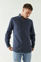 Camisa de gabardina gris con corte slim, mangas largas, cartera abotonada y dos bolsillos con solapa en el pecho.