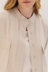 Sobrecamisa celeste de corte recto, con cuello mao, mangas 3/4 con puños y cierre frontal con botones. Tiene dos bolsillos de parche en el pecho.