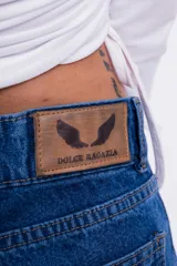 Pantalón de jean azul con parches en forma de estrella de un tono más claro y bordes desflecados.