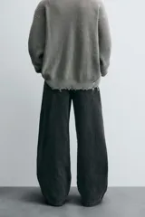 Pantalón de jean negro de corte amplio, estilo balloon fit, con cinco bolsillos y cierre frontal con botones.
