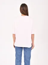 Remera rosa de corte holgado con estampado frontal que dice 'Los Angeles Malibu CA' en azul y naranja.