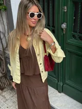 Camisa de denim celeste claro, de corte holgado, con cuello clásico, cierre frontal con botones a presión y bolsillos con solapa en el pecho.