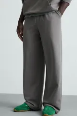 Pantalón jogger wide fit negro confeccionado en tejido de algodón con interior rizo. Pernera ancha, cintura elástica ajustable con cordón interior, bolsillos laterales y bolsillo trasero de plastrón.