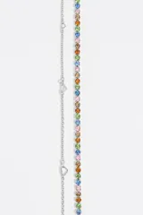 Collar de doble cadena que combina una hilera de cristales facetados en diversos colores (rosa, azul, amarillo, naranja y verde) con una cadena fina plateada adornada con pequeños dijes en forma de corazón. Cuenta con un cierre de mosquetón y un detalle circular con logo.