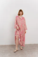 Vestido largo azul con estampado floral en tonos beige, confeccionado en viscosa. Presenta escote en V, botonadura completa en el frente y mangas largas con volados.