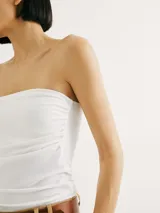 Top sin tirantes blanco, ajustado al cuerpo.