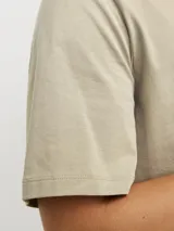 Camiseta color beige de manga corta y cuello redondo, corte relajado.