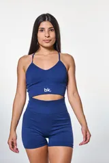 Conjunto deportivo azul marino compuesto por un top con breteles finos y logo blanco, y un short de cintura alta.