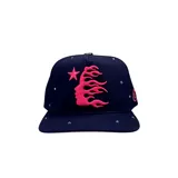 Gorro de visera plana color azul marino, con logo de Hellstar bordado en rosa en el frente, con forma de rostro y llamas. Tiene detalles de tachas plateadas en la visera y en los paneles laterales.