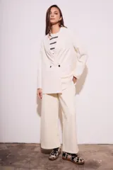 Blazer color crema de poliéster y viscosa, de corte oversize con solapas y doble botonadura.