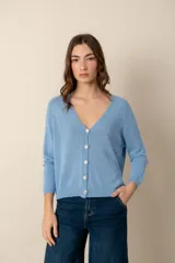 Cárdigan de punto color rosa claro, con escote en V y cierre frontal con botones nacarados.