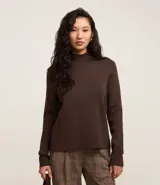 Sweater negro de punto con cuello redondo, puños y ruedo acanalados. Incluye cuello, puños y ruedo de camisa celeste a rayas.