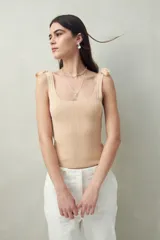 Top tejido color beige con tiras para anudar en los hombros y diseño tramado.