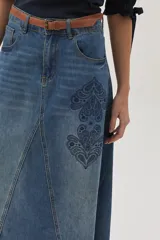Falda larga de jean celeste con corte evasé, tiro medio y detalles bordados en el frente.