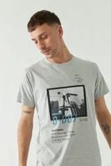 Remera gris de manga corta con estampa fotográfica de un edificio enmarcada en un cuadrado negro.