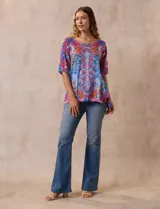Blusa de modal estampado con flores en tonos azules, rosas y amarillos, marca Ruby Rd. Tiene cuello redondo, manga corta con abertura y apliques de brillos en el frente.