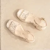 Sandalias de cuero color marrón con plataforma y tacón cuadrado. Tiras anchas sobre los dedos y tobillo con hebilla ajustable.