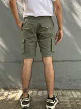 Bermuda de gabardina color marrón claro, corte recto, con bolsillos cargo laterales y bolsillos traseros con solapa.