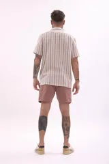 Camisa de manga corta con estampado a rayas verticales en tonos beige, marrón y celeste.