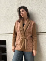 Chaqueta marrón con mangas largas, solapa ancha y cinturón con hebilla.