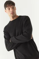 Sweater color verde oliva con textura acanalada en la parte superior del pecho y hombros.