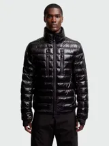 Campera de esquí acolchada color negro brillante, con cuello alto y cierre frontal. Presenta dos bolsillos verticales con cierre en el pecho y puños ajustados.