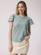 Remera color celeste con mangas cortas con volados de encaje.