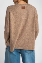 Sweater color marrón claro de tejido de punto, con cuello redondo y mangas largas.