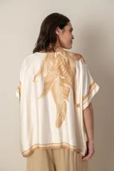 Blusa italiana color natural con estampado de hojas en tonos azules. De calce holgado y talle único.