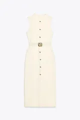 Vestido midi color crema, de cuello redondo y sin mangas. Presenta falsos botones frontales, cinturón elástico con aplique dorado, bolsillos de parche con solapa y abertura delantera.