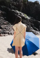 Vestido corto tipo camisa color beige con bordados florales en azul.