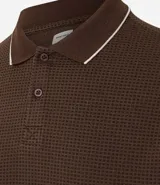 Polo de hombre color crema con textura waffle, cuello polo con botones, mangas cortas y ribete azul marino en cuello y mangas.