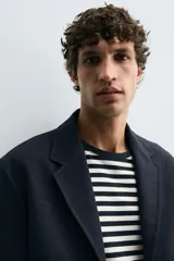 Blazer regular fit color azul marino, con cuello con solapas de muesca, manga larga con puño abotonado y bolsillos de solapa en la cadera. Incluye bolsillo interior y abertura en el centro de la espalda. Cierre frontal de botonadura simple.