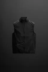 Chaleco negro de tejido técnico con estructura ripstop y ligero acolchado interior. Cuello alto ajustable con elástico, sisas amplias, bolsillos de seguridad con cremallera en pecho y cadera, acabados con cinta elástica, cierre frontal con cremallera y logo estampado en el bajo.