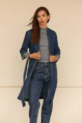 Trench vestido confeccionado en jean elastizado, con cierre delantero y frunce en la cintura.