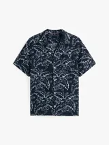 Camisa de manga corta con estampado floral en tonos azul y blanco.