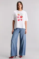 Remera blanca de algodón con cuello redondo y mangas cortas. Estampado frontal con diseño de frambuesas y texto 'Berry Into You'.