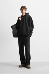 Pantalón wide fit confeccionado en tejido de algodón con interior en rizo, color negro. Cintura elástica ajustable con cordón interior, bolsillos frontales y detalle de bolsillo trasero de vivo. Perneras con costura frontal y efecto lavado.