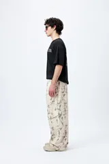 Pantalón cargo baggy con estampado abstracto en tonos neutros, bolsillos laterales y corte amplio.