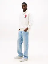 Zapatillas de estilo tenis confeccionadas en piel napa blanca, con diseño de corte bajo y cierre de cordones. Presentan un panel de contraste en el talón en color azul marino, forro de poliéster y suela de goma. Incluyen el parche distintivo de Tommy Jeans en el lateral.