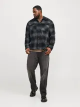 Sobrecamisa de hombre a cuadros grises y negros, de manga larga, con cuello clásico, bolsillos en el pecho y cierre con botones. Corte relajado diseñado para cuerpos plus size.