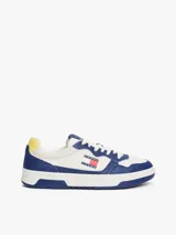 Zapatillas Tommy Jeans de corte bajo, confeccionadas en piel color blanco y azul con detalles en amarillo. Presentan suela cupsole, detalle de ventilación en la parte superior, logo de Tommy Jeans en relieve en la entresuela y parche de Tommy en el lateral.