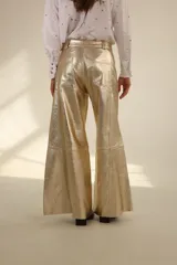 Pantalón dorado de cuero sintético, corte wide leg y tiro alto.